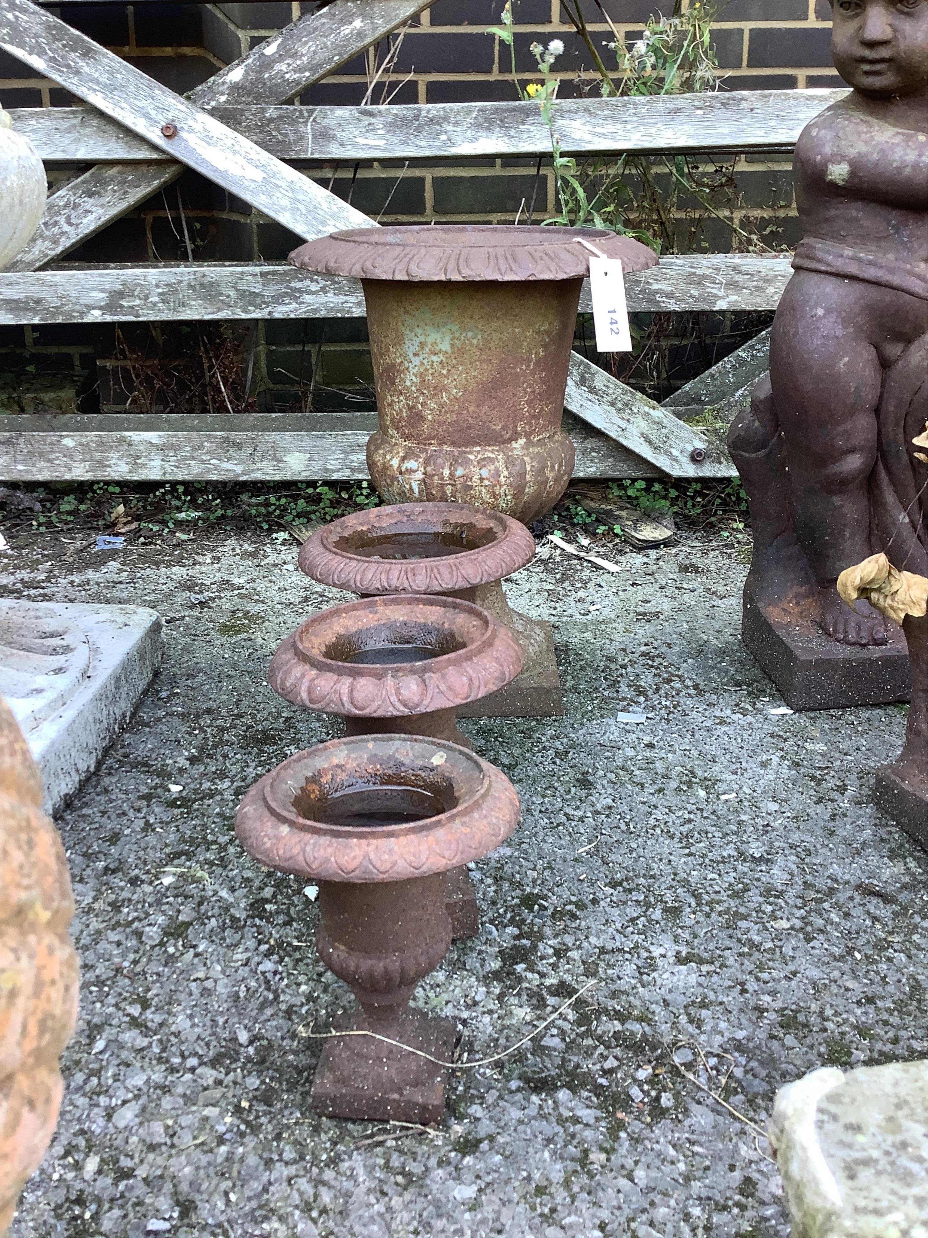 Four Victorian style cast iron campana garden urns, largest height 42cm. Condition - fair